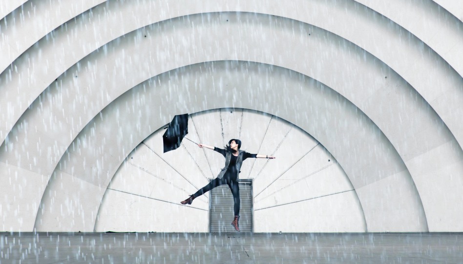 Frau tanzt voller Freude im Regen